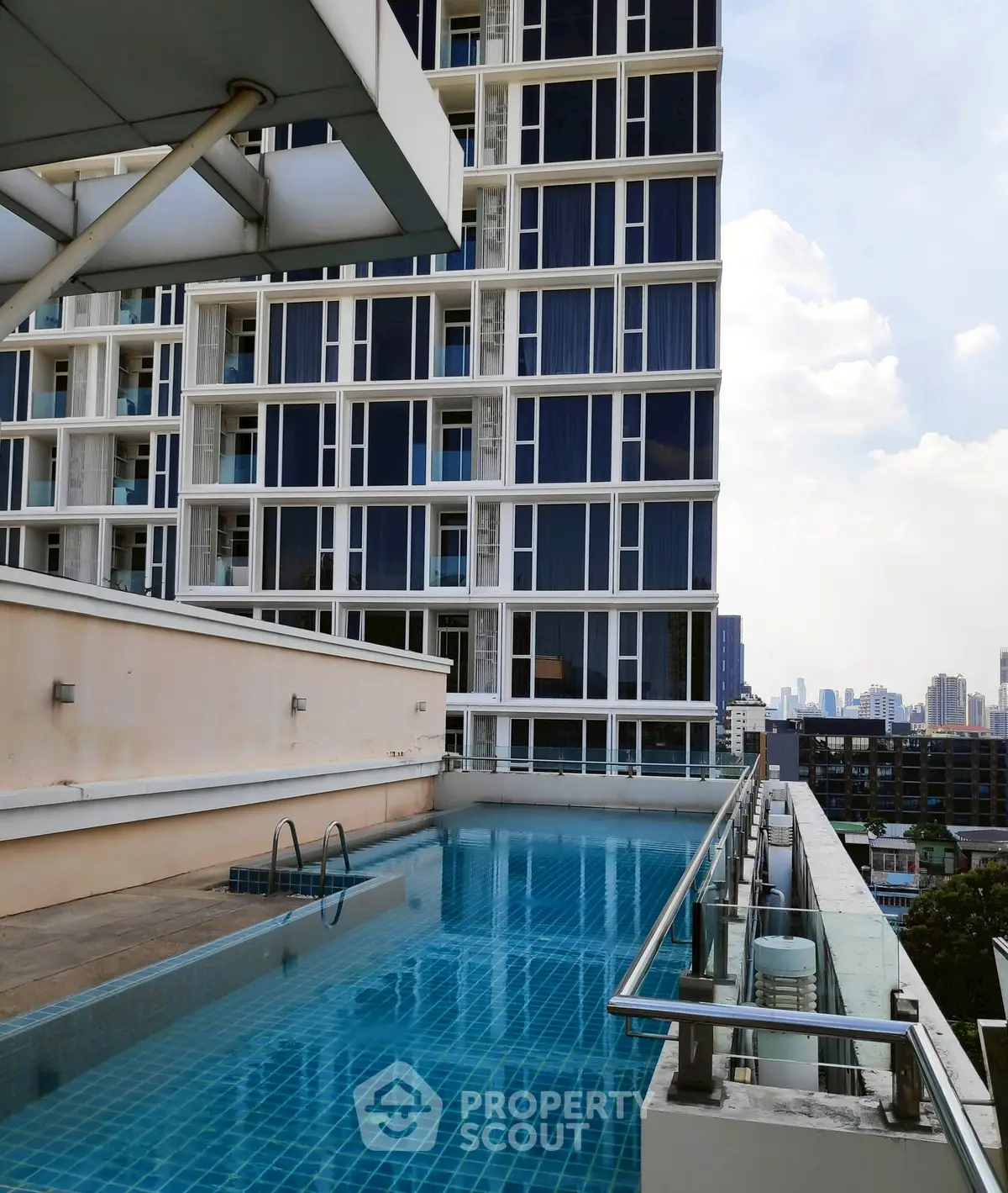 Modern high-rise building with rooftop pool offering stunning city views.