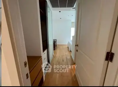 Spacious bedroom entrance with wooden flooring and ample storage space.