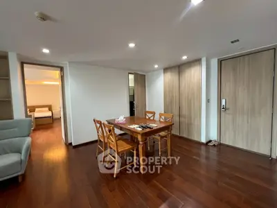 Spacious dining area with wooden flooring and modern furniture in a cozy apartment.