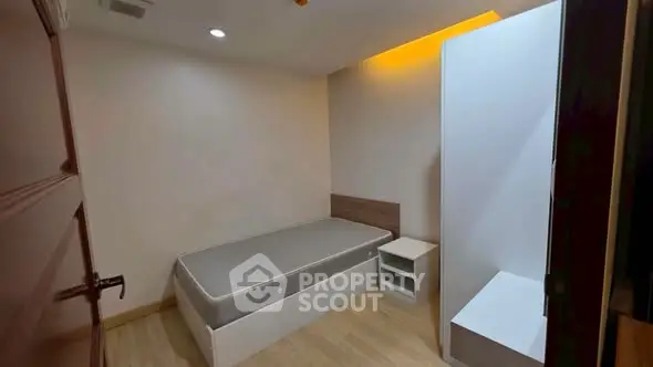 Cozy minimalist bedroom with modern lighting and wooden flooring