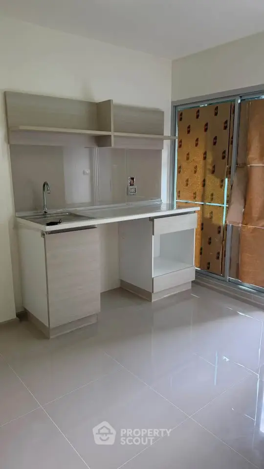 Modern kitchen with sleek cabinetry and large window, perfect for natural light.