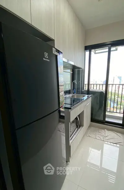 Modern kitchen with sleek black fridge and city view from window