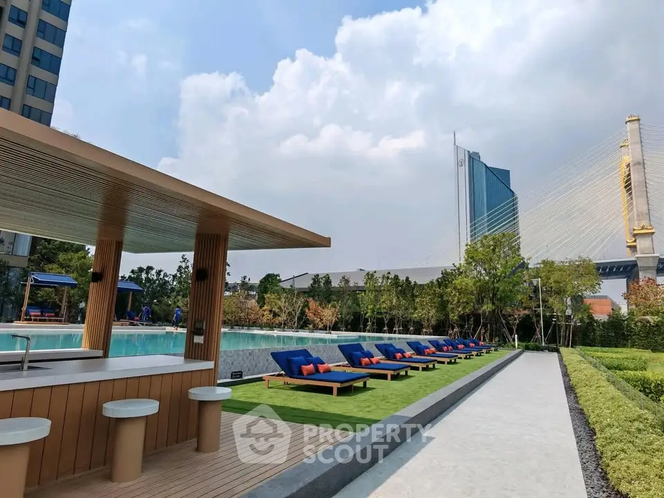 Luxurious outdoor pool area with sun loungers and modern architecture, perfect for relaxation and leisure.