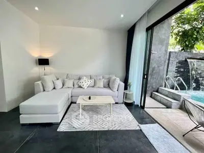 Modern living room with pool view, featuring stylish furniture and open sliding doors for indoor-outdoor living.