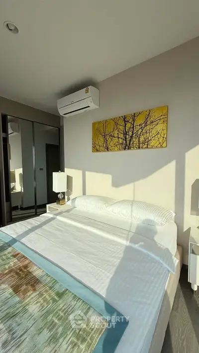 Modern bedroom with large window, stylish decor, and air conditioning unit, offering a cozy and bright living space.