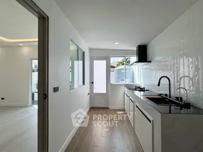 Modern kitchen with sleek design and natural light, featuring a gas stove and open layout.
