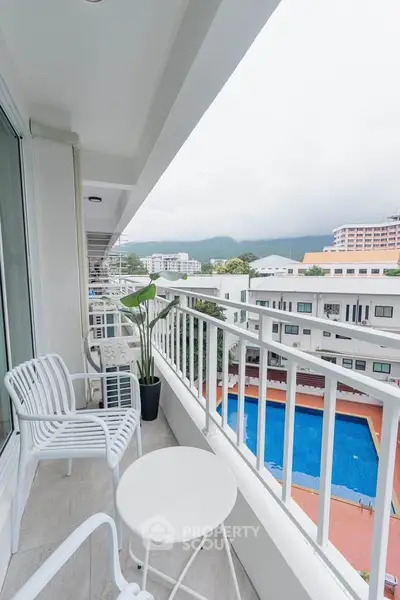 Spacious balcony with stunning pool view in modern apartment complex.