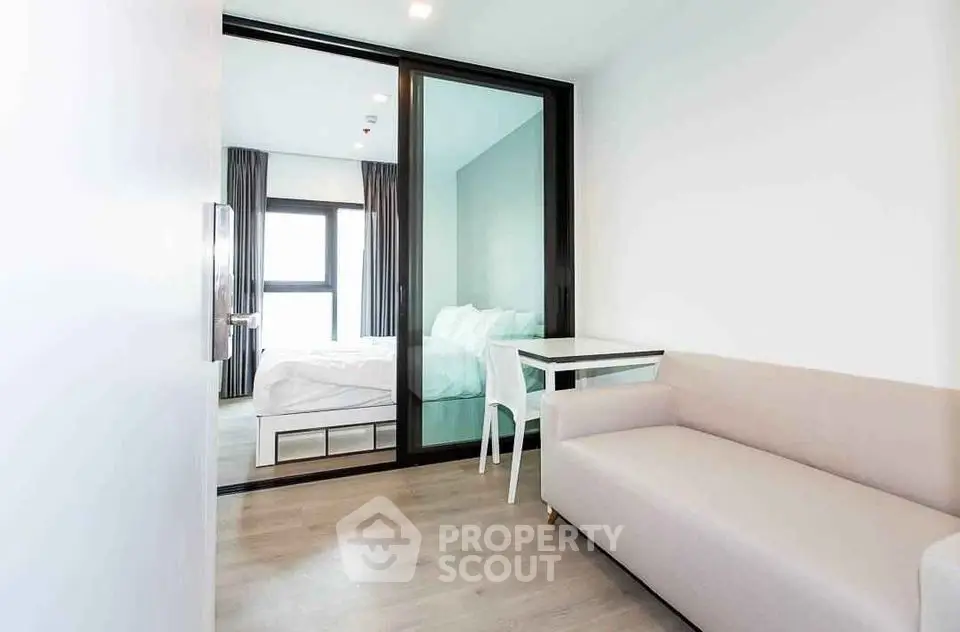 Modern bedroom with glass partition and cozy seating area