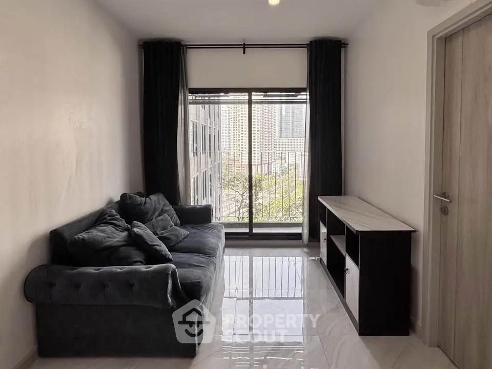 Modern living room with city view, featuring a plush sofa and sleek storage unit.