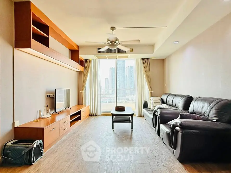 Spacious living room with modern furniture and city view, perfect for relaxation and entertainment.