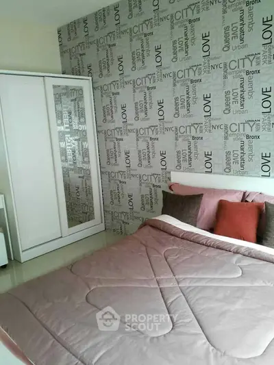 Modern bedroom with stylish wallpaper and cozy bedding in a contemporary apartment.