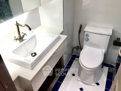 Modern bathroom with elegant fixtures and white ceramic tiles.