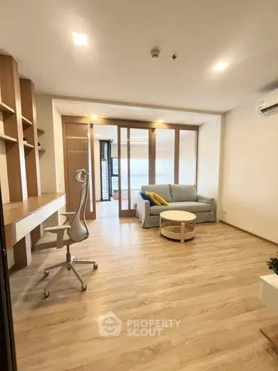 Modern living room with wooden flooring, stylish furniture, and natural light.