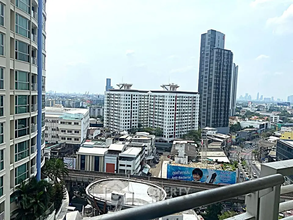 Stunning cityscape view from a high-rise balcony overlooking urban skyline and modern architecture.