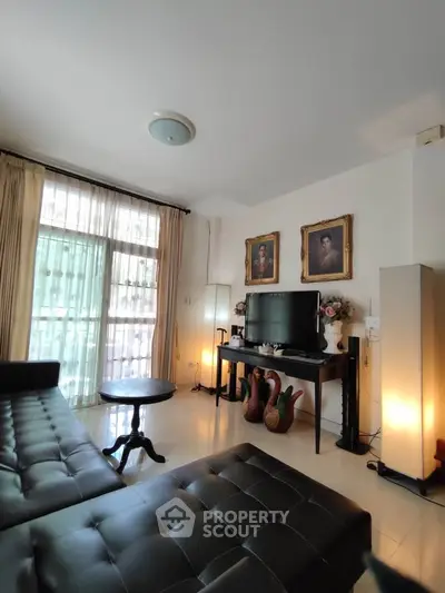 Elegant living room with leather sofa and large window, perfect for relaxation.