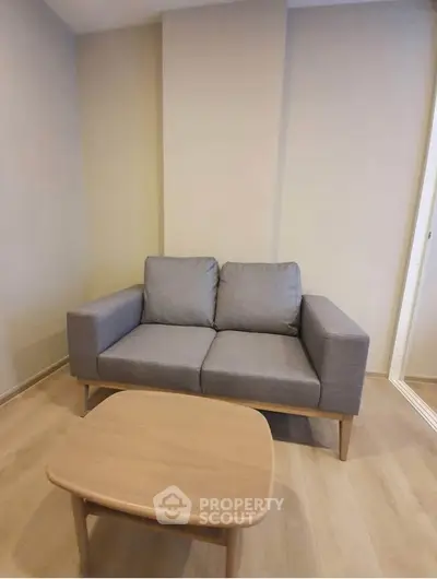 Cozy living room with modern gray sofa and wooden coffee table, perfect for relaxation.