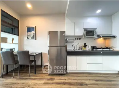 Modern kitchen with sleek appliances and dining area in stylish apartment