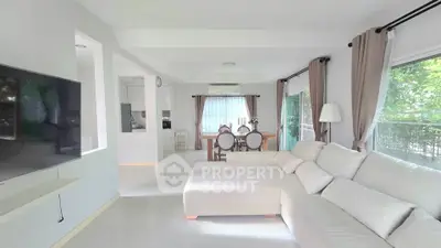 Spacious living room with modern decor and large windows offering natural light.