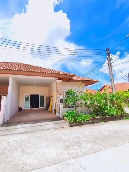 Charming suburban home with lush garden and spacious driveway under a clear blue sky.