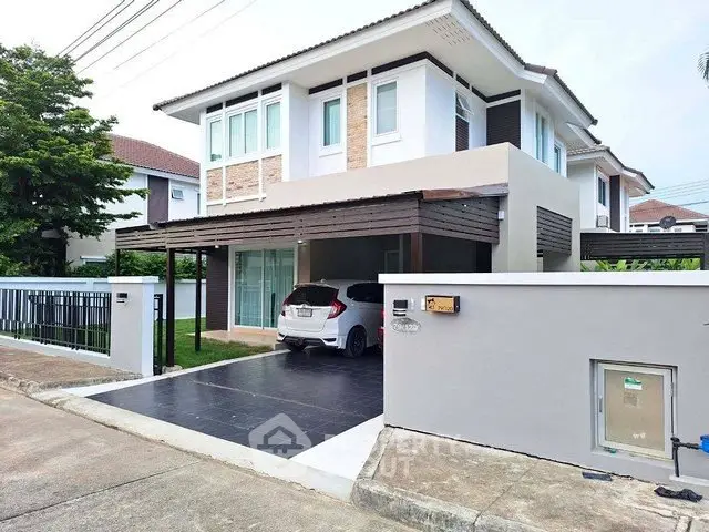Modern two-story house with carport and sleek exterior design in a suburban neighborhood.