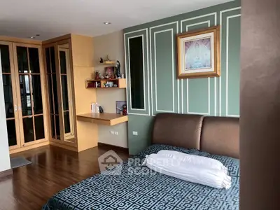Elegant bedroom with stylish decor and built-in wooden wardrobe, featuring a cozy bed and modern wall accents.