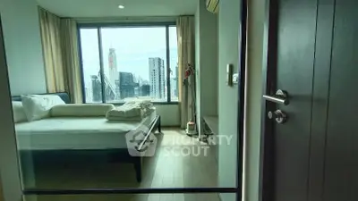 Modern bedroom with city view, large windows, and minimalist decor in a high-rise apartment.