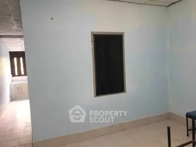Spacious room with tiled floor and window, ideal for customization and personal touch.