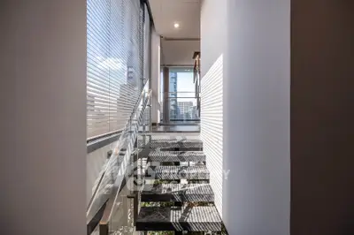 Modern corridor with glass railing and city view, perfect for urban living.