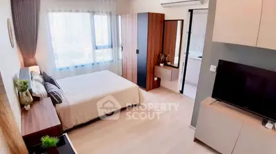 Modern bedroom with stylish decor, large window, and sleek furniture in a contemporary apartment.