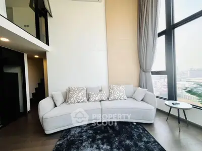 Modern living room with stylish sofa and large windows offering city view