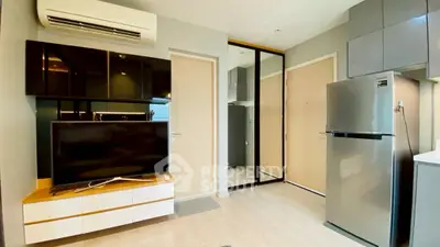 Modern living room with sleek furniture and stainless steel appliances in a stylish apartment.