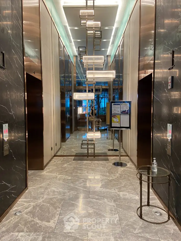 Luxurious modern elevator lobby with marble floors and elegant lighting.