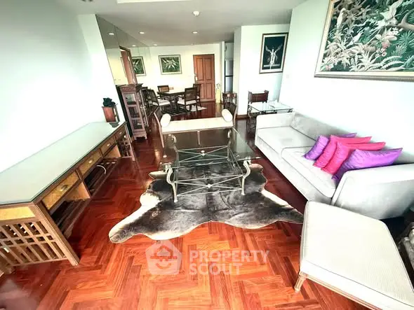 Spacious living room with elegant hardwood floors and stylish furniture, perfect for modern living.