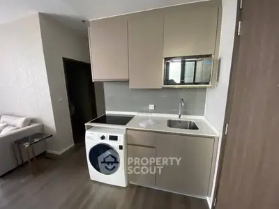 Modern compact kitchen with integrated washing machine and sleek cabinetry