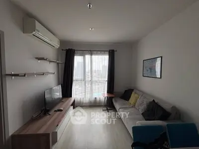 Modern living room with city view, featuring a cozy sofa, wall-mounted TV, and air conditioning.