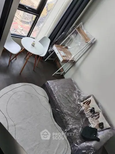 Modern living room with large window and stylish furniture in urban apartment