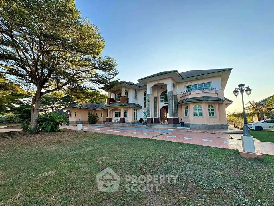 Stunning luxury mansion with expansive lawn and elegant architecture, perfect for upscale living.