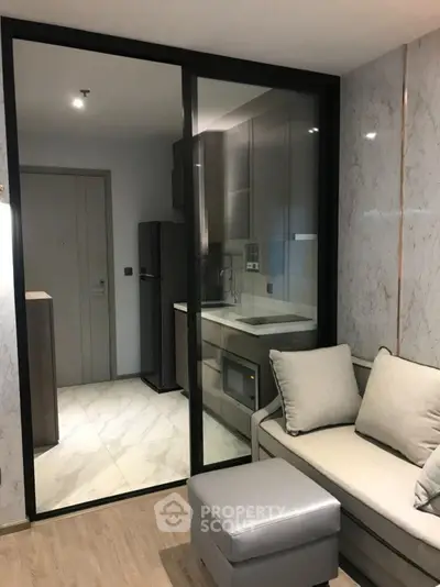 Modern apartment with sleek kitchen and cozy living area, featuring elegant marble walls and contemporary furniture.
