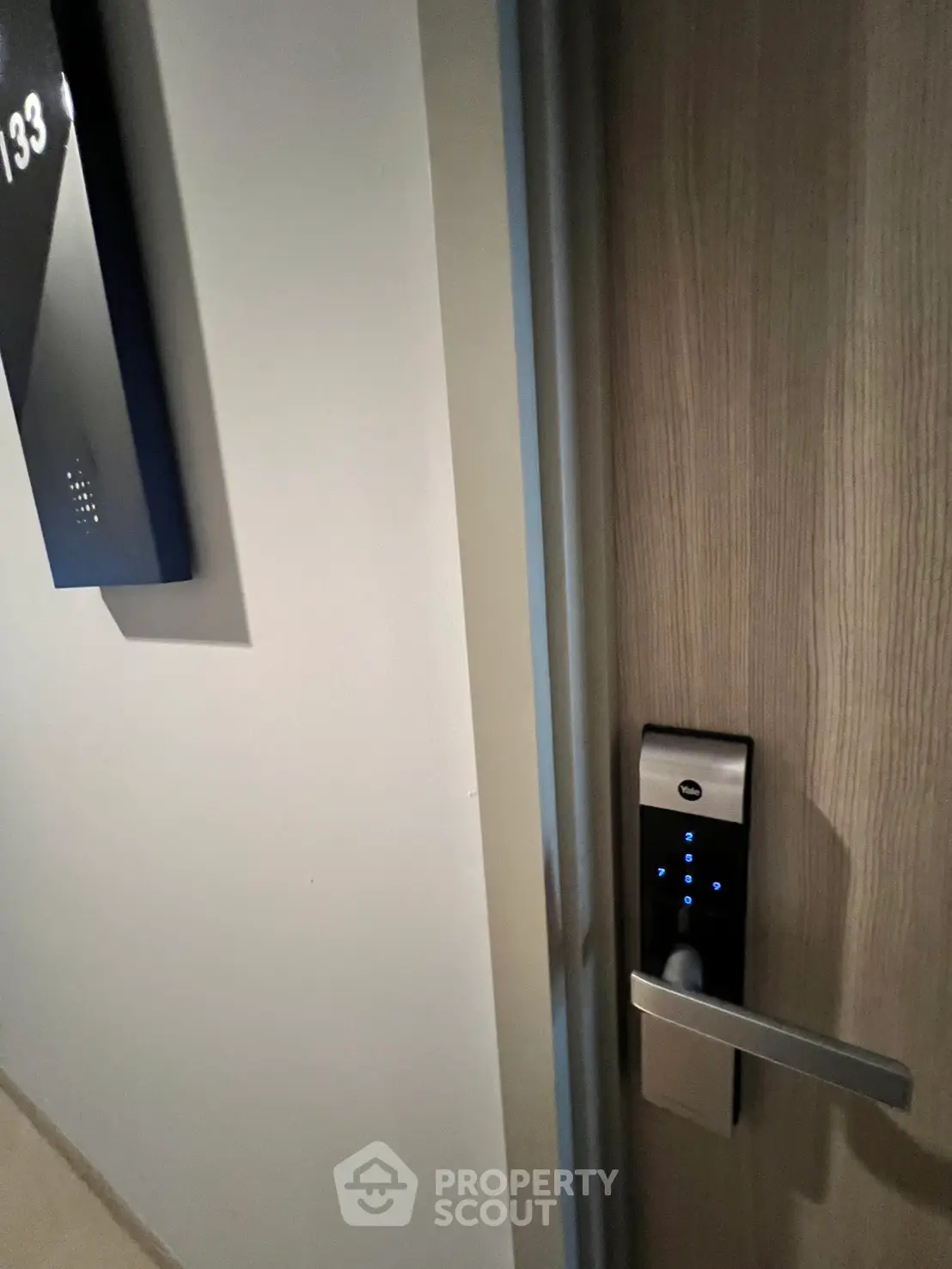 Modern apartment entrance with digital lock and room number display