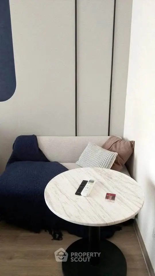 Cozy corner with a small sofa and round marble table in a modern apartment.