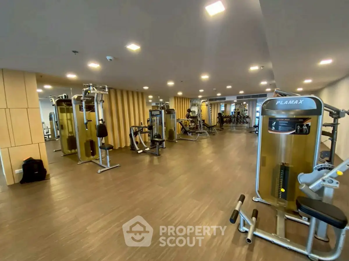 Spacious modern gym with state-of-the-art fitness equipment in luxury residential building.