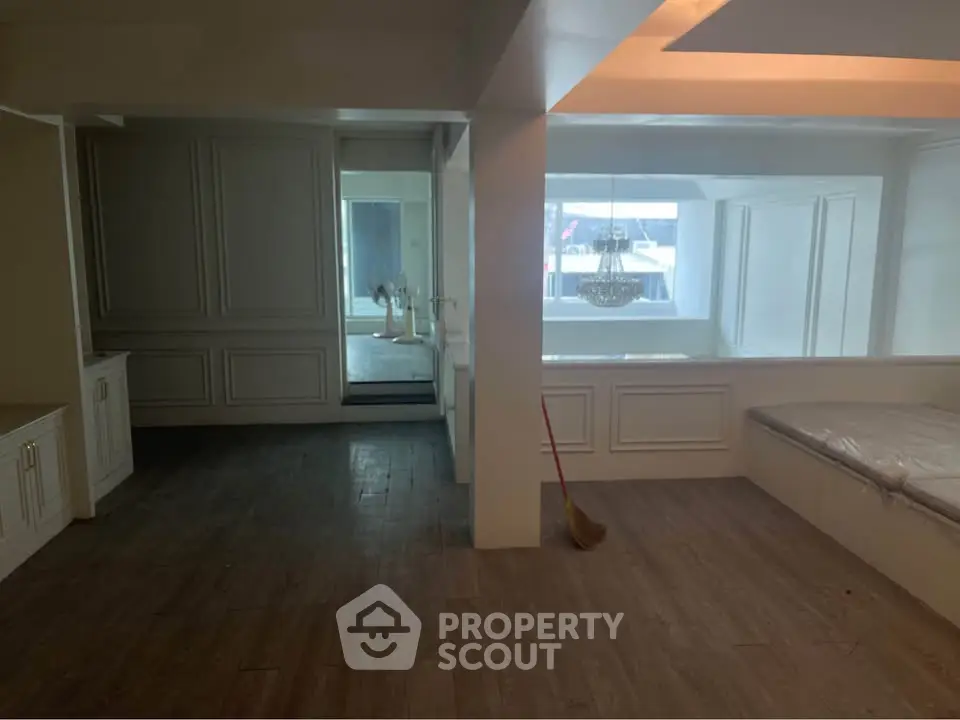 Spacious interior with elegant wood flooring and large windows, perfect for modern living.