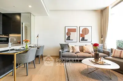 Modern living room with stylish decor and open kitchen layout, featuring elegant furniture and natural light.