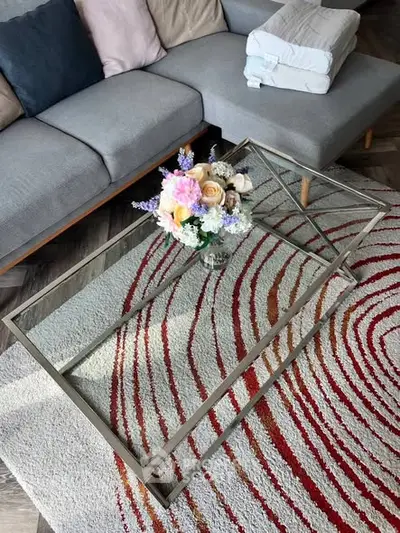 Stylish living room with modern glass coffee table and vibrant rug