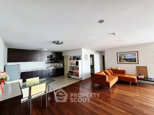 Spacious open-plan living room with modern kitchen and hardwood floors