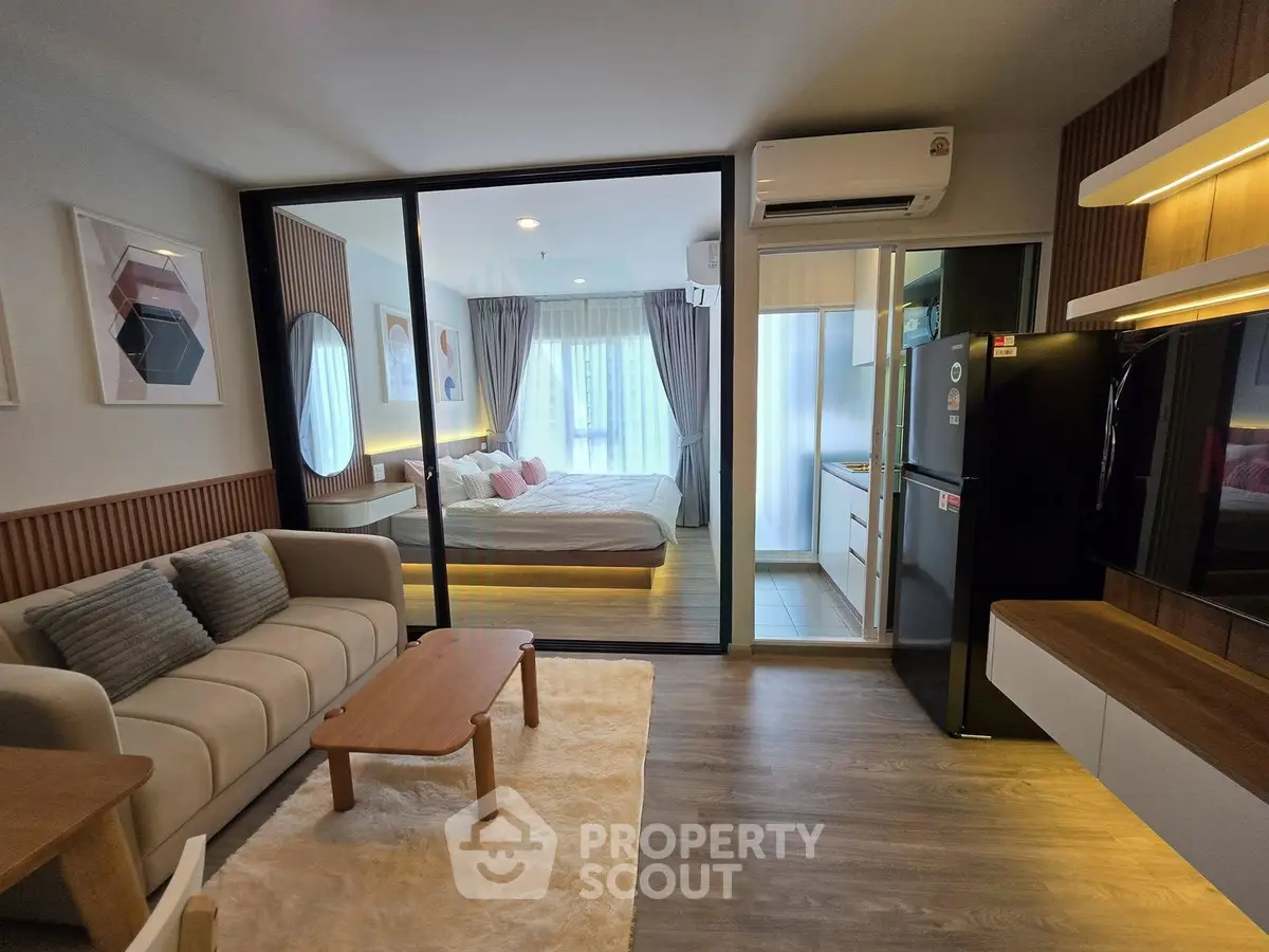 Modern open-plan living room with cozy bedroom and sleek kitchen in stylish apartment