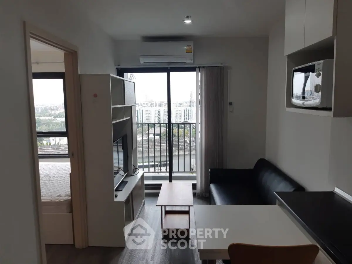 Modern apartment living room with balcony view and sleek furnishings.