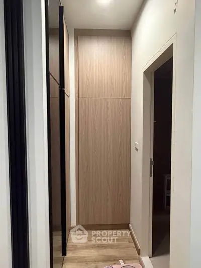 Modern hallway with sleek wooden cabinetry and elegant flooring