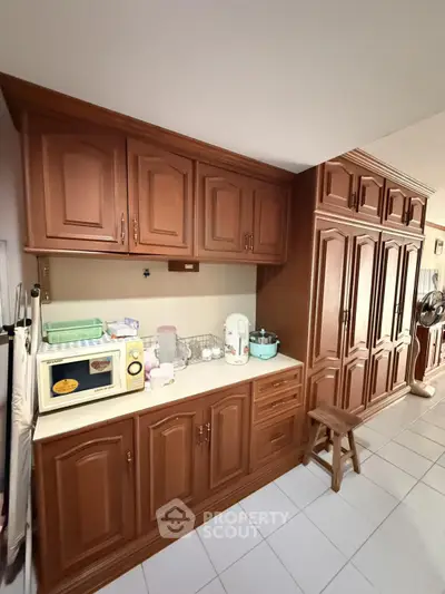Spacious kitchen with wooden cabinets and modern appliances in a cozy home setting.