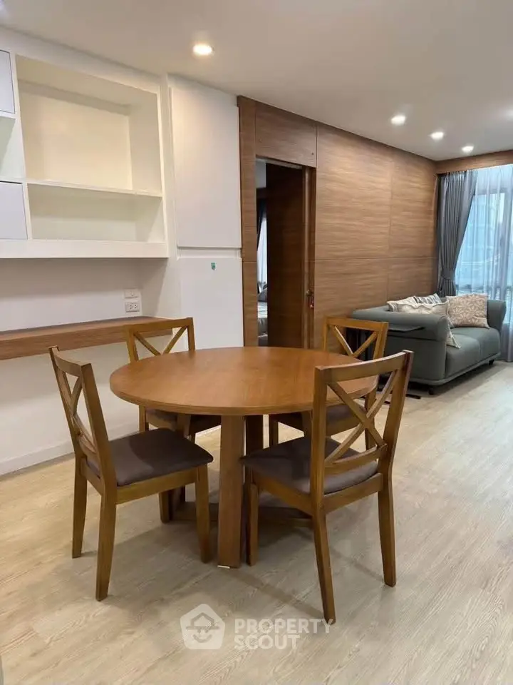 Spacious living room with elegant wooden dining set and cozy seating area, perfect for modern living.